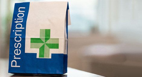 A paper prescriptions bag on a desk
